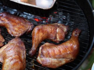 Hot smoking chicken legs in a smokehouse at home